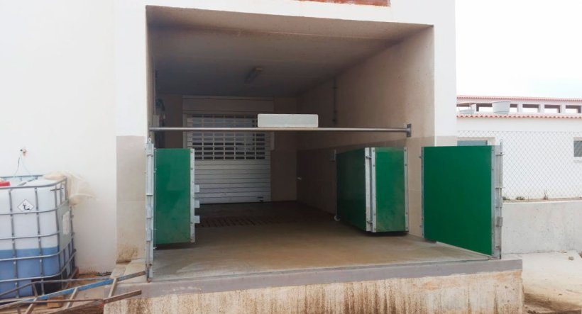Imagen 6. Cargador semi-cerrado con puertas y barra horizontal para separar f&iacute;sicamente la zona sucia de la limpia. Cortes&iacute;a de Agropecuaria Los Girasoles, Espa&ntilde;a.
